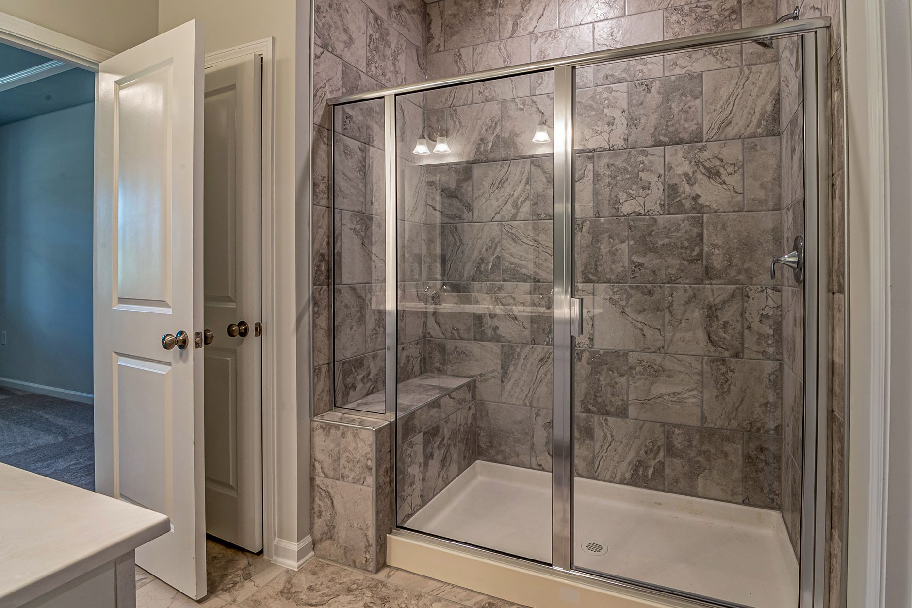 Luxurious modern bathroom with marble tiled shower and sleek glass doors in Riverside, CA